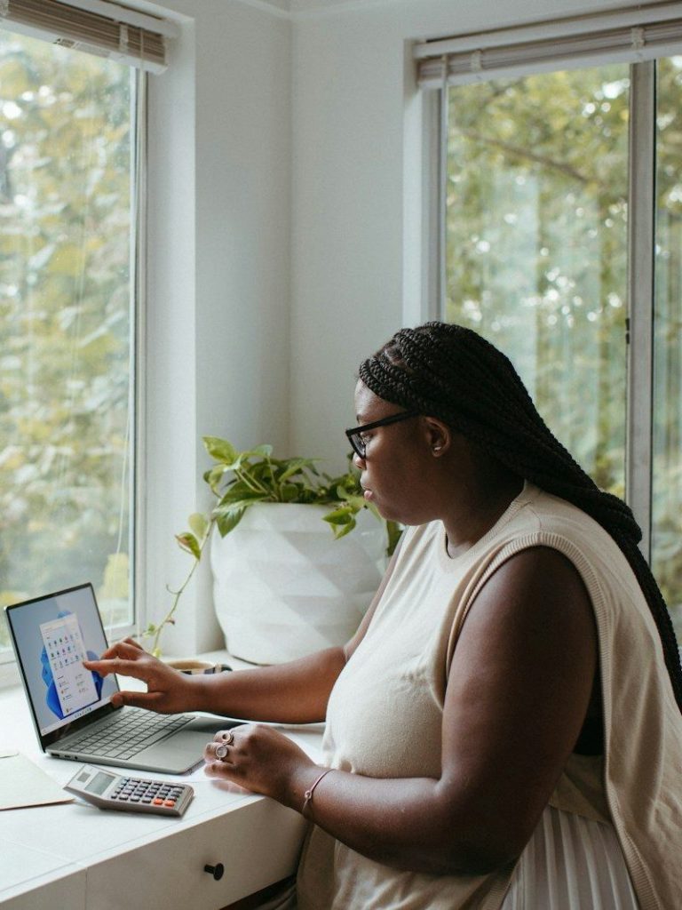 a woman sitting at a table with a laptop